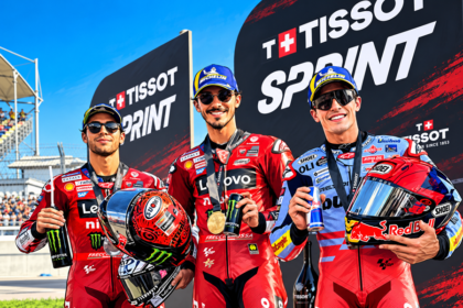 Ilustrasi AI tiga pembalap MotoGP berpose di podium Tissot Sprint dengan seragam balap dan helm.