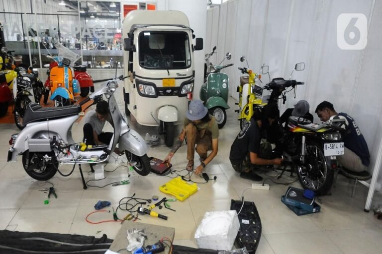 Bengkel motor listrik dengan teknisi sedang melakukan perbaikan dan perawatan