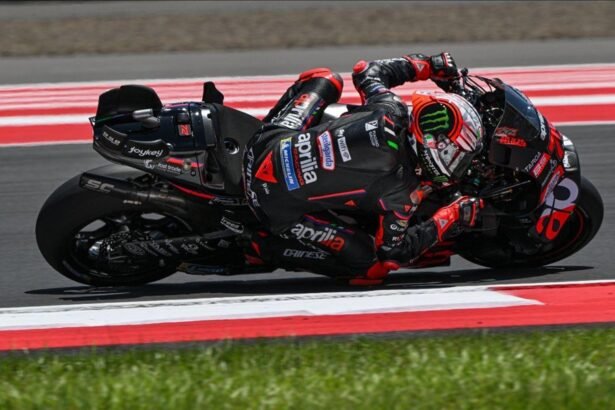 Ilustrasi AI pembalap Aprilia MotoGP dengan motor hitam merah saat menikung ekstrem di lintasan balap.