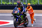 Ilustrasi AI pembalap Yamaha MotoGP didorong marshal saat berada di lintasan sirkuit.